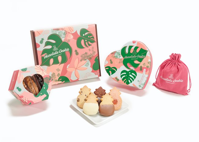 Various Valentines Collection packages next to a plate of pineapple-shaped shortbread cookies from Honolulu Cookie Company