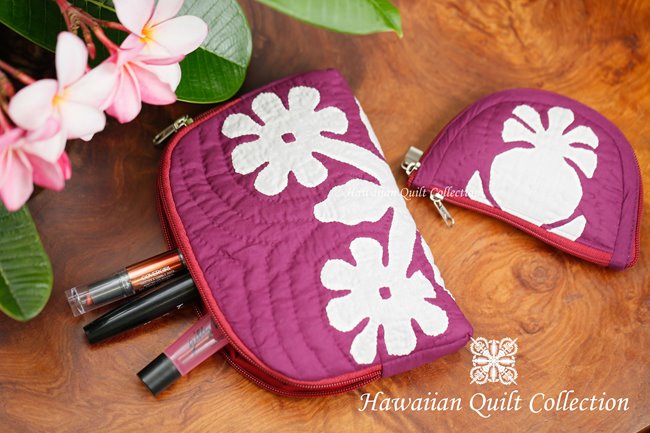 2 pink quilted makeup bags with Hawaiian motifs.