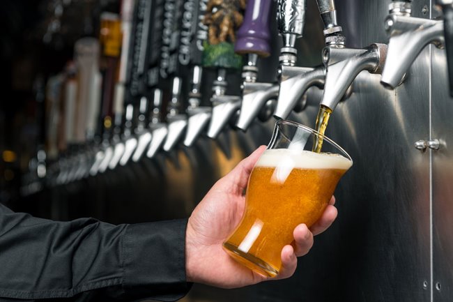 A glass of Yard House's 23rd anniversary beer being poured from draft