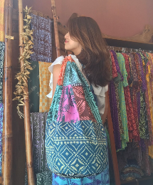 Female model carrying blue & pink bag with multiple tapa patterns