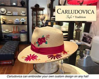 A tan hat with a red band and embroidered flowers