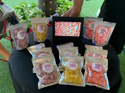 Different flavors of packaged hard candy on a table at the Beach Walk farmers market in Waikiki.