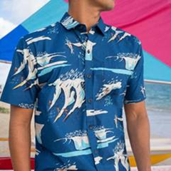 Man wearing a retro blue aloha shirt with surfers & ocean waves on it, which was designed by Nick Kuchar for Kahala.
