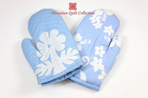 Light blue Hawaii Quilt Collection oven mitts with island patterns.