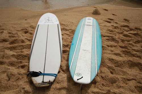 White and blue surfboards on the sand at the beach in Waikiki