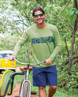 Tribal_Wave.jpg Man wearing a green long sleeve while standing next to a bike in the forest
