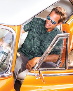 Daily_Catch.jpg Man wearing a teal tribal polo shirt while sitting in a yellow car