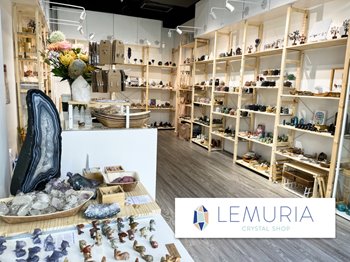 Crystal shop interior with shelves displaying various crystals and minerals, featuring the 'Lemuria Crystal Shop' logo